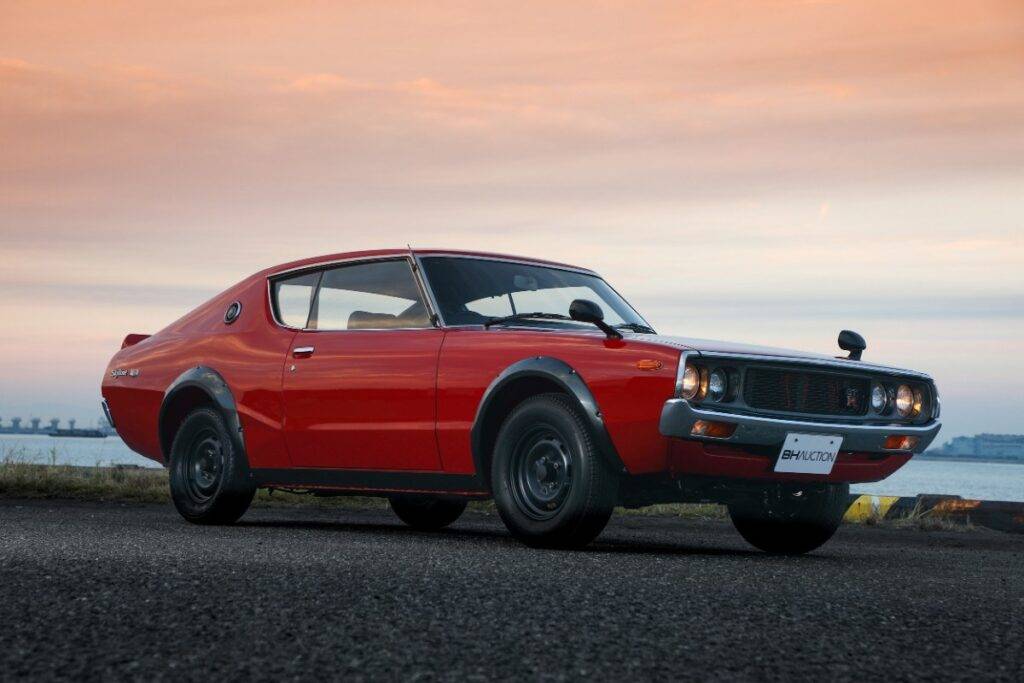 una Nissan Skyline GT-R rossa e sullo sfondo la luce del tramonto - sei nel posto giusto