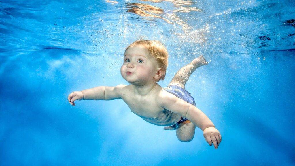 a beautiful serene baby swimming soaked in wonderful blue water